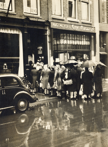 68254 Afbeelding van een rij wachtenden voor de kristal- en glaswinkel W. Reinders & Co. (Oudkerkhof 35) te Utrecht ...